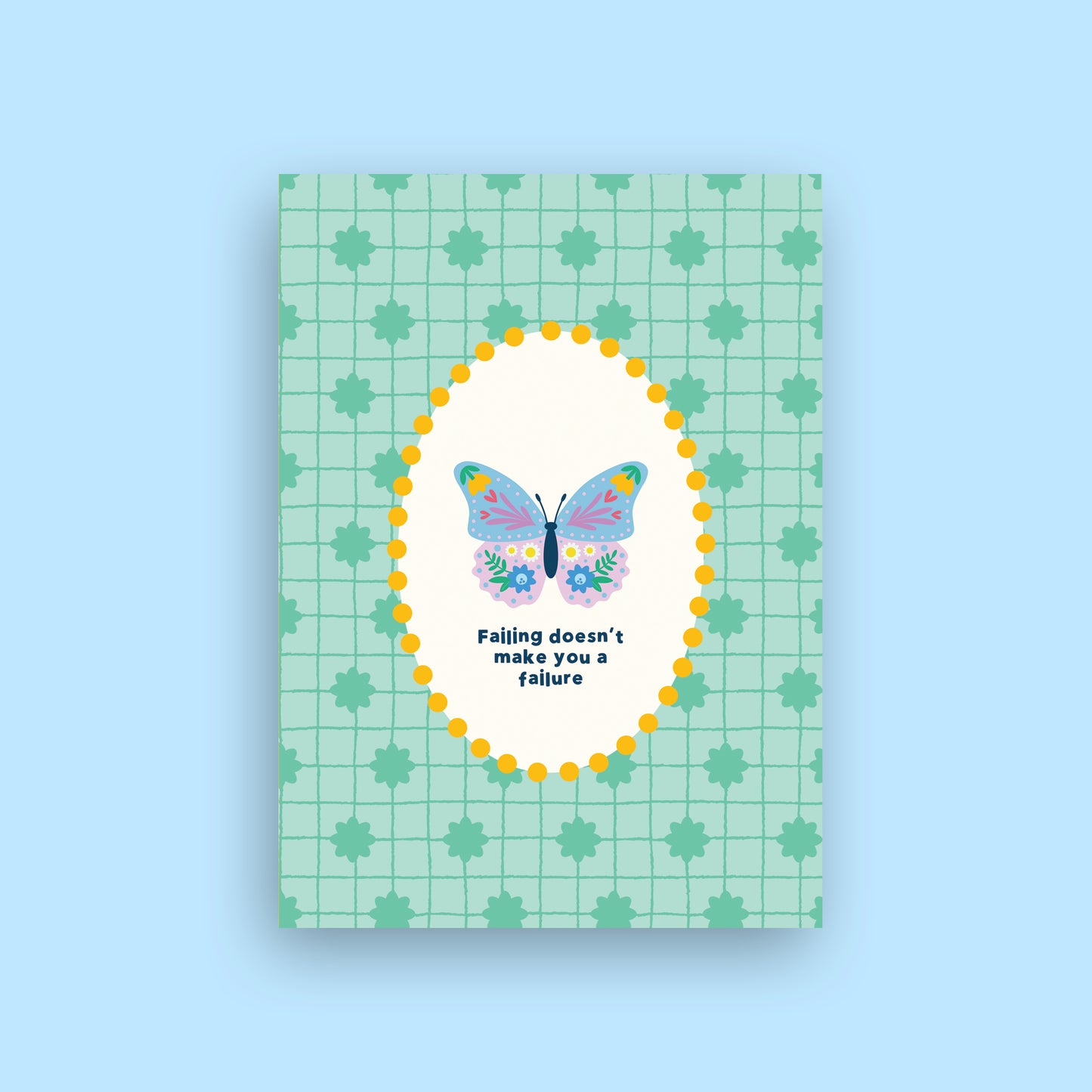 A rectangular greeting card with a mint green grid and leaf pattern, featuring a central white oval with a colorful butterfly and the text 'Falling doesn't make you a failure'. The card is shown against a solid light blue background.